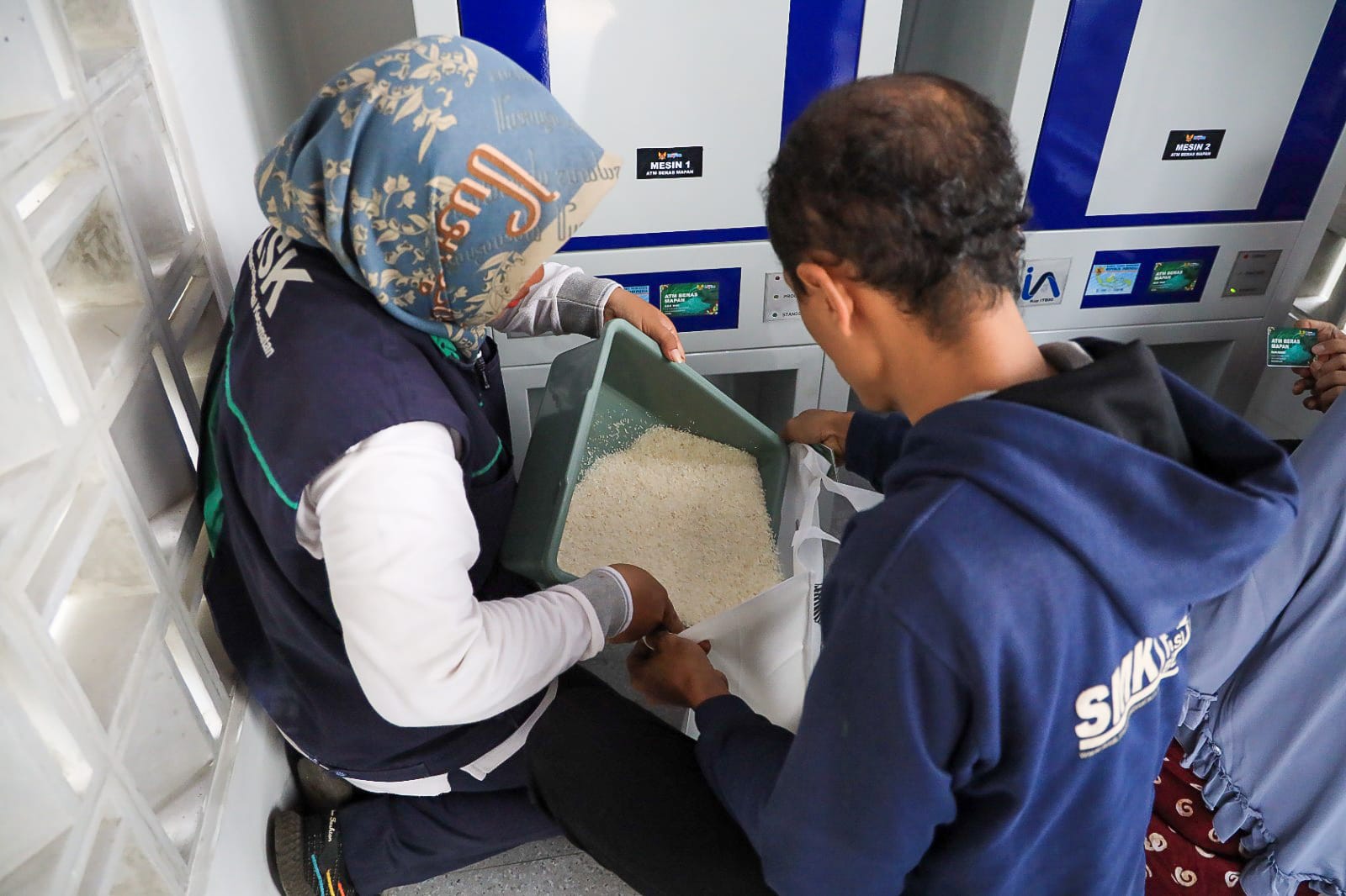 Salah seorang warga Kota Kediri saat menerima beras dari ATM Beras. (Ist).