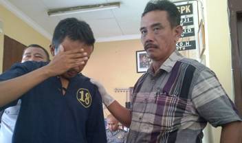 Herman saat digelandang ke Polsek Kenjeran. foto: rusmiyanto/BANGSAONLINE
