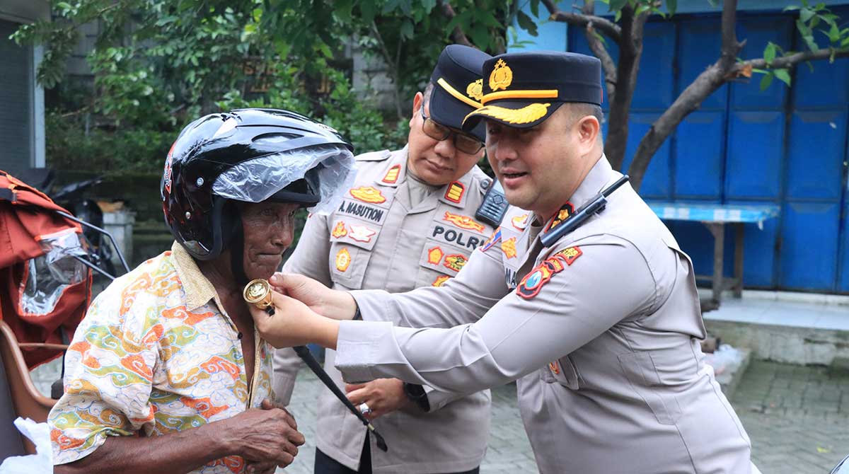 Kapolres Gresik, AKBP Ramadhan Nasution, saat memakaikan helm dalam Operasi Keselamatan Semeru 2026. Foto: Ist