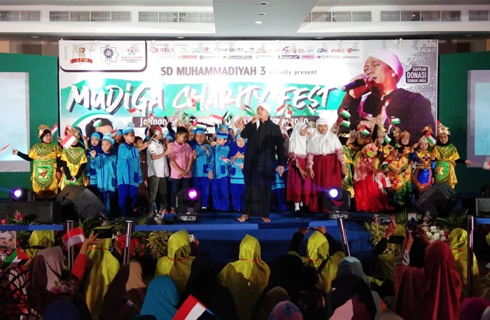 Penampilan Opick saat menghibur para tamu undangan, dilatarbelakangi murid-murid SD Muhammadiyah 3 Surabaya yang membawa bendera Palestina dan bendera Merah Putih berukuran kecil. Foto: YUDI ARIANTO/BANGSAONLINE