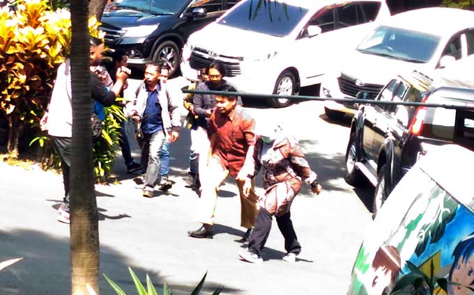 Salah satu pejabat Kota Malang dikawal ketat personel KPK saat mengambil berkas di mobilnya. 