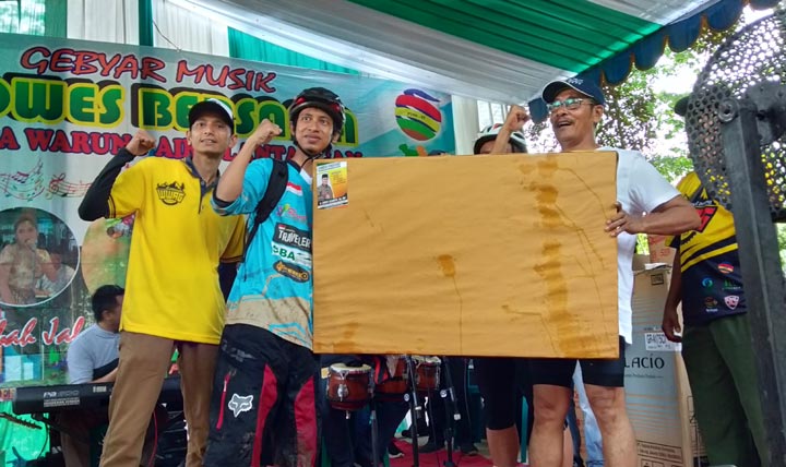 H. Djoko Susanto menyerahkan hadiah doorprize televisi kepada salah seorang peserta gowes.
