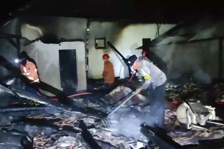 Polisi dan petugas damkar saat menyisir puing rumah warga usai api berhasil dipadamkan