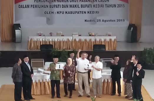 Dua pasangan calon bupati saat menunjukkan hasil pengundian nomor urut. (arif kurniawan/BANGSAONLINE)
