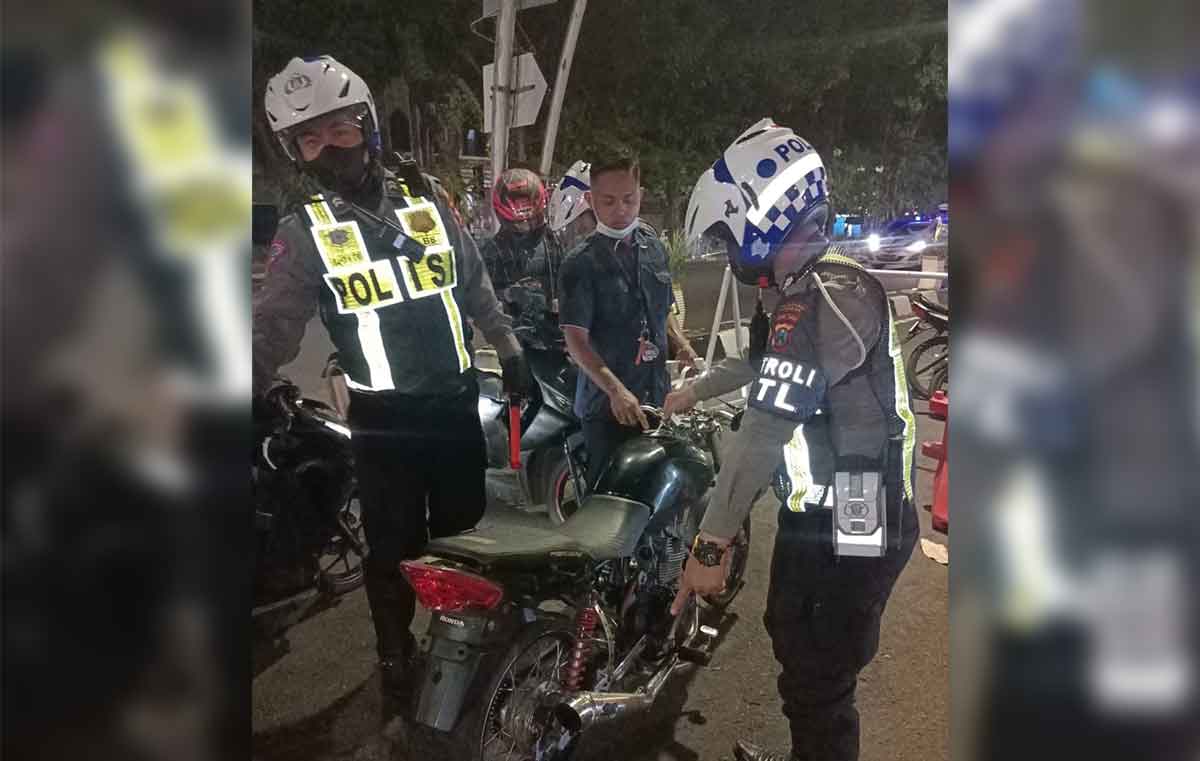 Petugas patroli dari Satlantas Polrestabes Surabaya saat menindak pelanggar.
