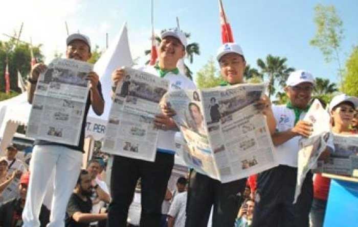 Menpora Imam Nahrawi membaca koran HARIAN BANGSA saat acara jalan sehat Surabaya Berjalan yang digelar HARIAN BANGSA dan bangsaonline.com di parkir timur Delta Plasa Surabaya. Tampak Menpora didampingi Wakil Wali Kota Surabaya Wisnu Sakti Buana dan Direktur HARIAN BANGSA dan bangsaonline.com M Mas