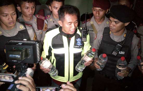 Kasat Reskrim Polres Gresik AKP Iwan Hari Poerwanto menunjukkan BB miras hasil razia. (foto: syuhud/BANGSAONLINE)
