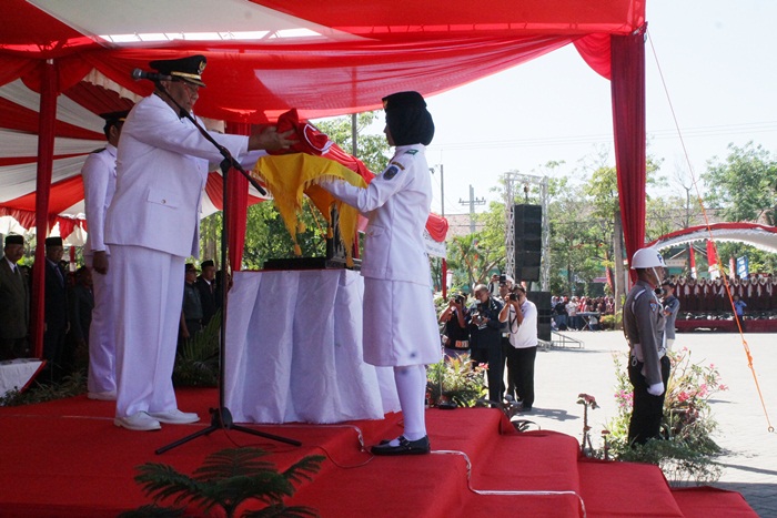 Pj Bupati Nganjuk Sudjono saat menyerahkan bendera kepada petugas Paskibraka. Foto: BAMBANG/ BANGSAONLINE