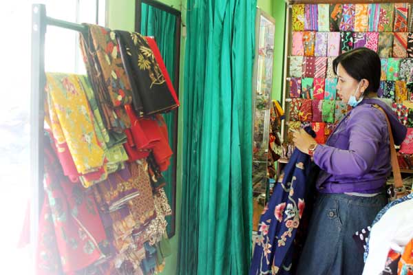 Satu calon pembeli kebingungan memilih motif batik. foto: faratiti dewi/BANGSA ONLINE