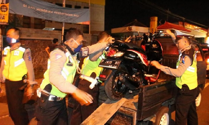 Petugas mengangkut salah satu motor.
