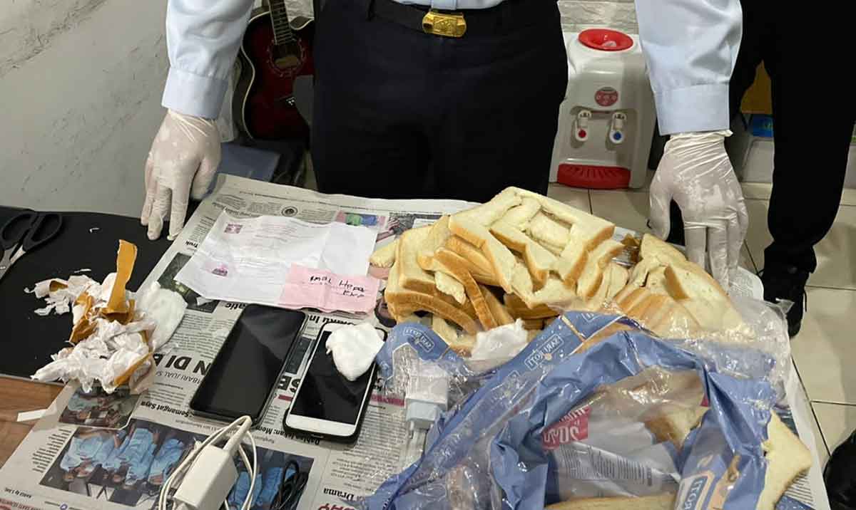 Petugas Lapas Kediri saat mengamankan barang bukti berupa roti tawar yang berisi HP dan charger. Foto: Ist