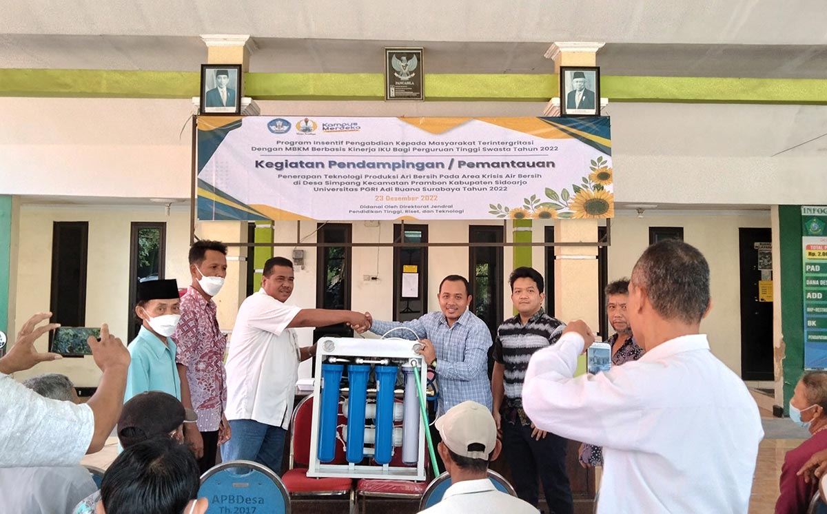 SIMBOLIS: Tim Dosen Unipa Surabaya menyerahkan alat penjernih air ke Desa Simpang Prambon, Sidoarjo, Rabu (21/12/2022). Foto: Ist.