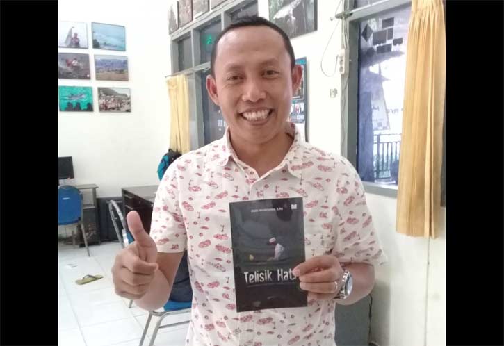 Ketua Komunitas Wartawan Gresik (KWG) M. Syuhud Almanfaluty menunjukkan buku Telisik Hati karya Didik Hendriyono.