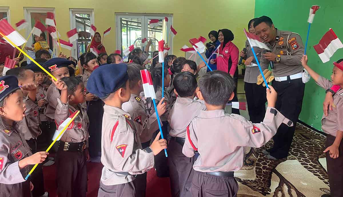 Petugas dari Satlantas Polres Pasuruan saat membagikan Bendera Merah Putih dalam rangka menyambut HUT ke-80 RI.