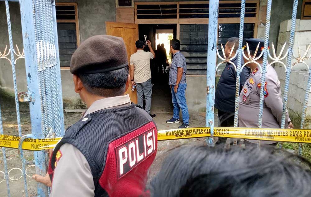 Petugas Polres Tuban memasang garis polisi di rumah kosong yang menjadi lokasi temuan granat.
