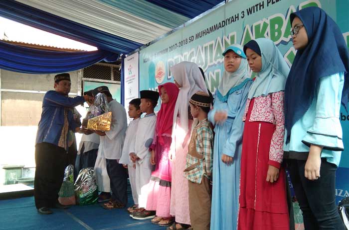 Kepala Sekolah SD Muhammmadiyah 3 Surabaya M Ali Imron saat menyerahkan santunan kepada anak-anak yatim.