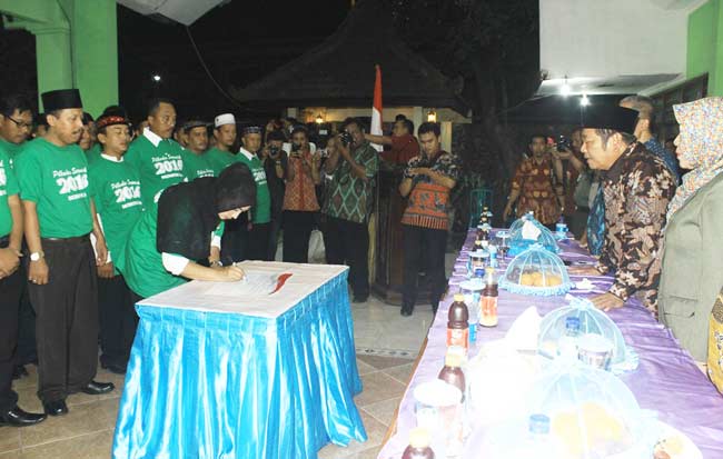 TEKEN: Salah satu calon Kades meneken ikrar Pilkades Damai, di Kantor Kecamatan Krian, Sidoarjo, Rabu (6/4) malam. foto: humas pemkab sidoarjo untuk BANGSAONLINE