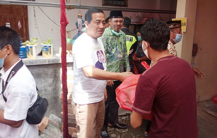 Tuan rumah didampingi Cabup Pungkasiadi saat membagikan paket sembako kepada warga. foto: SOFFAN/ BANGSAONLINE