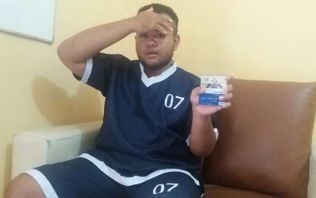 Tersangka menunjukkan barang bukti berupa STNK dan ATM. 