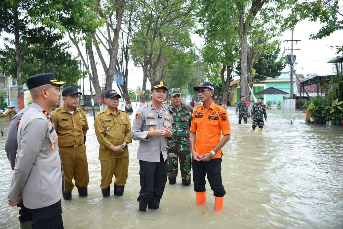 Kapolres Gresik AKBP Rovan Richard Mahenu bersama Kepala BPBD Kabupaten Gresik Sukardi, meninjau lokasi yang dilanda banjir di Kecamatan Benjeng, Gresik, Jawa Timur, Selasa (10/6/2025). Foto: Dok. Polres Gresik