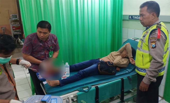 Petugas Lantas Polsek Porong, Aiptu Khoiron (kanan) melihat kondisi korban di RS. Bhayangkara Pusdik Gasum Porong.