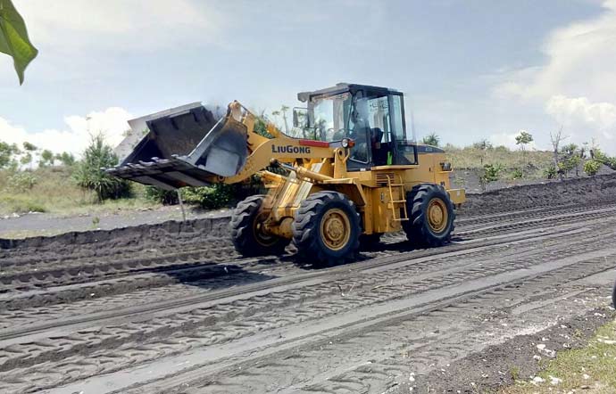 Alat berat saat meratakan gumuk pasir di pesisir selatan Lumajang. Area ini akan digunakan sebagai arena pacuan kuda, namun diprotes sejumlah warga desa Wotgalih.