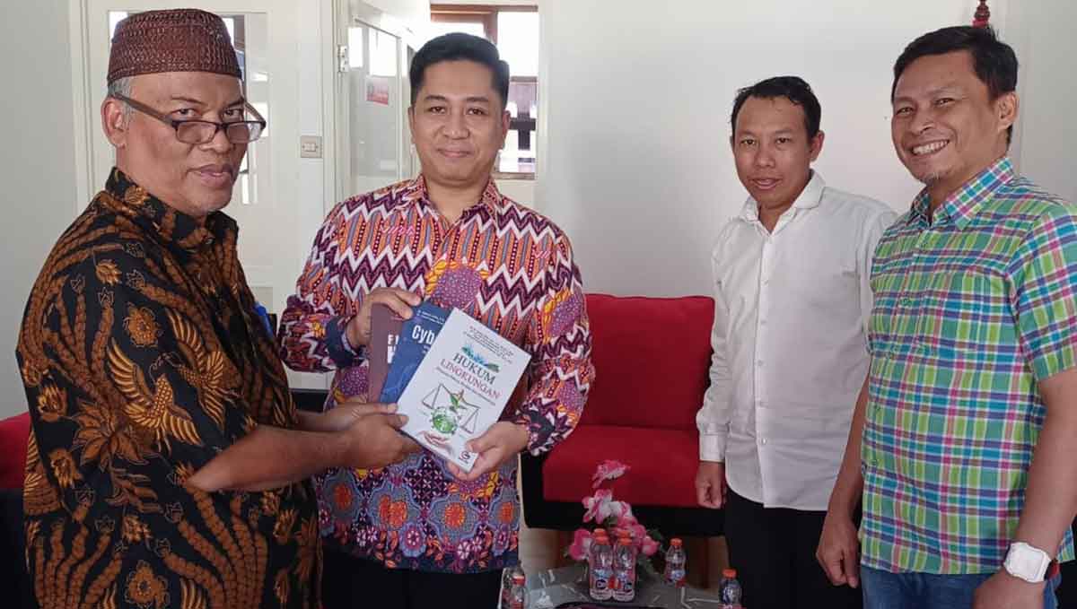 Dekan FH Uniska, Zainal Arifin (kiri), saat menyerahkan cendera mata berupa buku kepada Ketua PN Kota Kediri. Foto: Ist