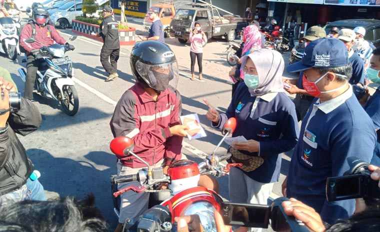 Petugas Dinkes Ngawi saat membagi-bagikan masker gratis di Perempatan Kartonyono.