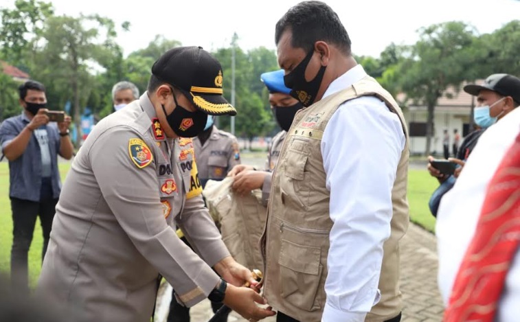 Tampak AKBP Dony Alexander Kapolreskab Mojokerto sedang memakaikan rompi pada Tim Khusus Anti Mony Politics.
