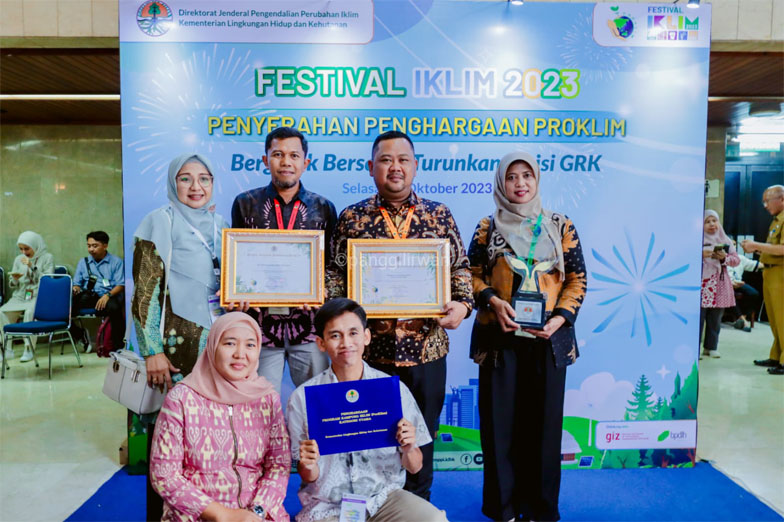 Bupati Gresik (dua dari kanan belakang) bersama Kadis LH menunjukkan penghargaan dari LHK RI.