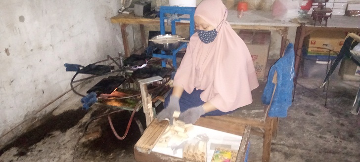 Tasdirin saat proses pembuatan kue gapit.