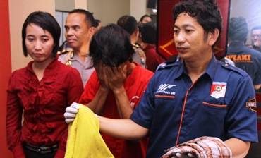 Tersangka (tengah) saat dikeler ke Mapolrestabes Surabaya. foto: rusmiyanto/BANGSAONLINE
