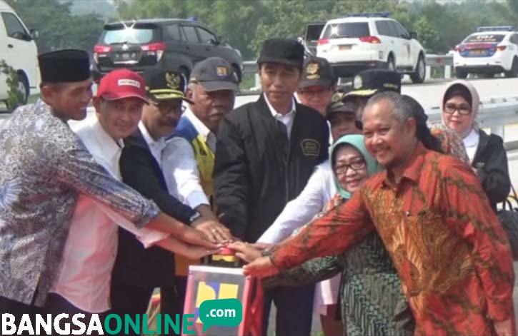 Jokowi bersama Menteri PUPR Basuki Hadimoeljono, Gubernur Jatim Soekarwo, serta sejumlah pejabat memencet tombol tanda peresmian tol trans Jawa.