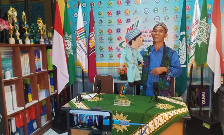 Kak Anshori bersama bonekanya saat mendongeng dalam kegiatan Darul Arqom. (foto: ist)