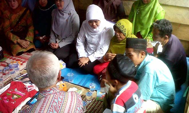 Menteri Sosial Khofifah Indar Parawansa di tengah keluarga almarhum Yuyun saat berkunjung ke rumah duka. 