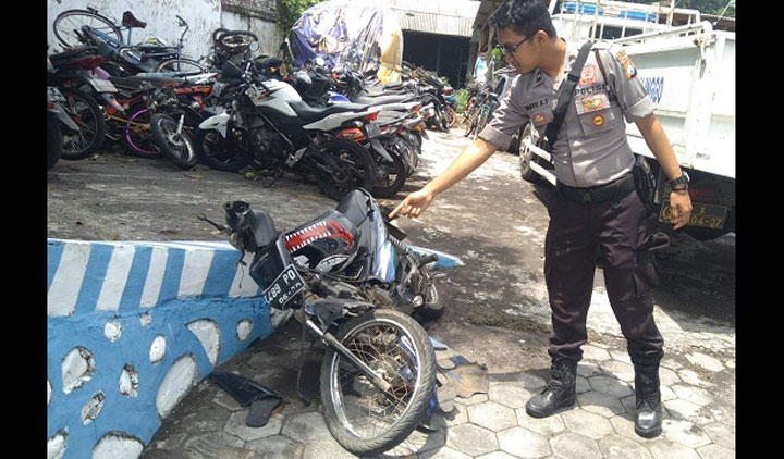 Petugas menunjukkan motor korban yang tampak ringsek usai dihantam pikap.