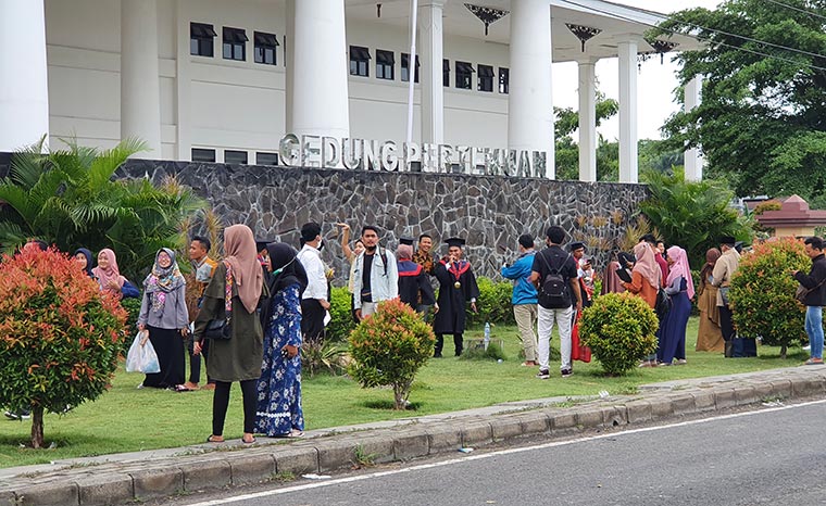 Wisudawan-wisudawati saat mengambil foto di depan logo Gedung UTM, Rabu (25/11/2020).