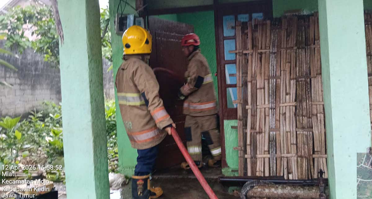 Petugas saat memadamkan api yang membakar sebuah rumah di Desa Mlati, Kecamatan Mojo, Kabupaten Kediri.