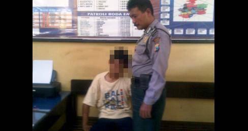 Tri saat didampingi petugas Polsekta Nganjuk saat akan menjalani interogasi. foto: Soewandito/BangsaOnline.com