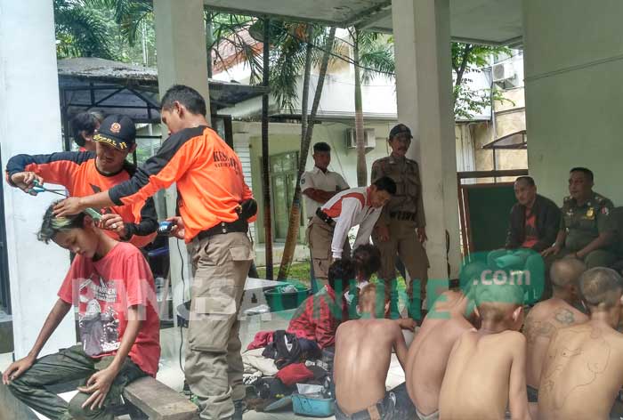 Para siswa yang ketahuan bolos sekolah digunduli oleh petugas Satpol PP. foto: EKY NURHADI/ BANGSAONLINE