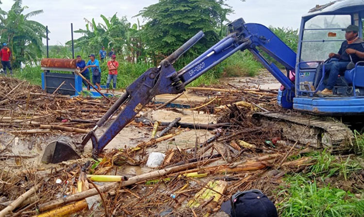 Petugas dengan alat ekskavator saat membersihkan rumpon bambu yang menyumbat Anak Sungai Kali Lamong. (foto: ist)