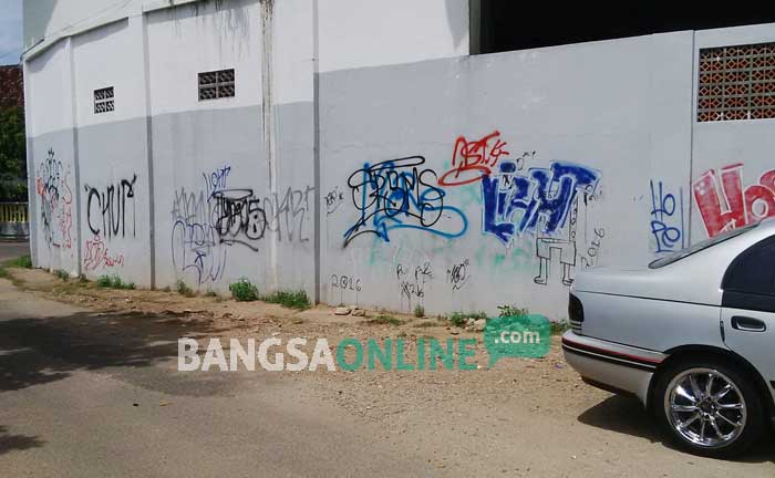 Corat-coret di pagar keliling SMPN 1 Pacitan, belum dibersihkan pihak sekolah.