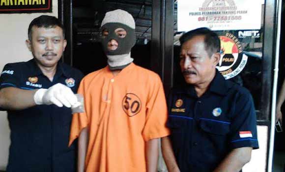 Tersangka diapit petugas Pplres Tanjung Perak. foto: ist