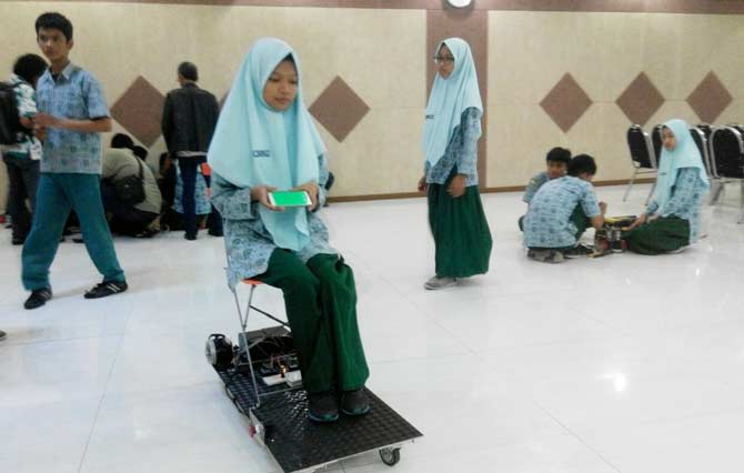 TEST DRIVE: Siswa Smamda Sidoarjo, Shafira QS, mencoba prototipe kendaraan elektrik berbasis android, di Aula Smamda, Rabu (26/10). foto: mustain/ bangsaonline