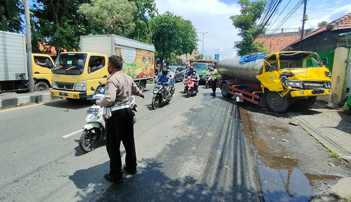 Petugas kepolisian saat mengevakuasi truk tangki air yang mengalami rem blong di Jalan Raya A Yani Sidoarjo.