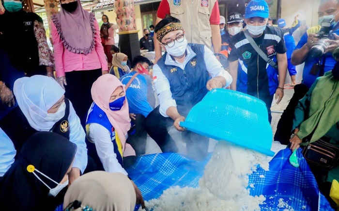 Gubernur Jatim Khofifah bersama Bupati Baddrut Tamam bersama para relawan dapur umum saat menyediakan makanan bagi warga yang terdampak banjir di Kabupaten Pamekasan.