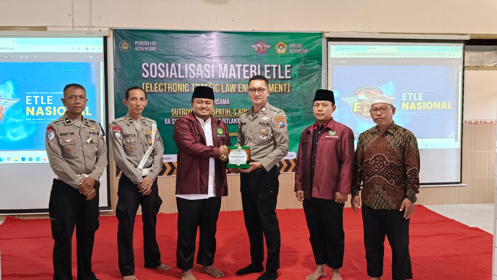 Ketua Pemuda LDII Kota Kediri, Asyhari Eko Prayitno (nomor 3 dari kiri) saat menyerahkan cinderamata kepada Sutriyono Krispatih dari BA Sigar Subdit Gakkum Ditlantas Polda Jatim. Foto: Muji Harjita/BANGSAONLINE