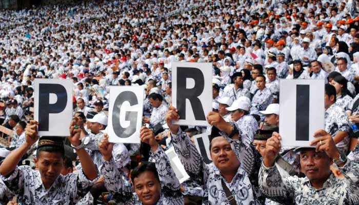 PERINGATI HUT: Sejumlah guru membentangkan poster bertuliskan PGRI saat mengikuti peringatan puncak HUT ke-70 PGRI, di GBK, Jakarta, Minggu (13/12). foto: poskotanews
