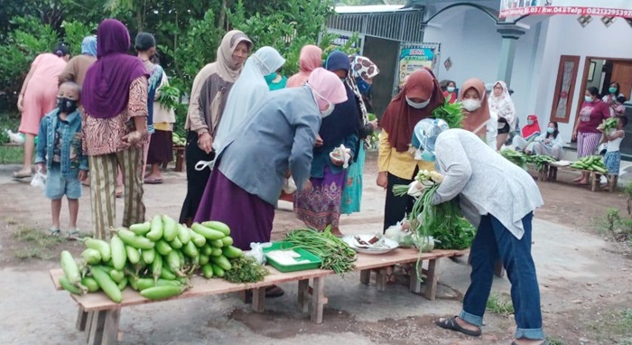 Ibu-ibu sedang sibuk memilih sayuran yang dibutuhkan untuk memasak menu hari ini. 