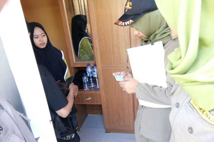 Petugas saat memeriksa salah satu penghuni kos. foto: SUWANDI/ BANGSAONLINE